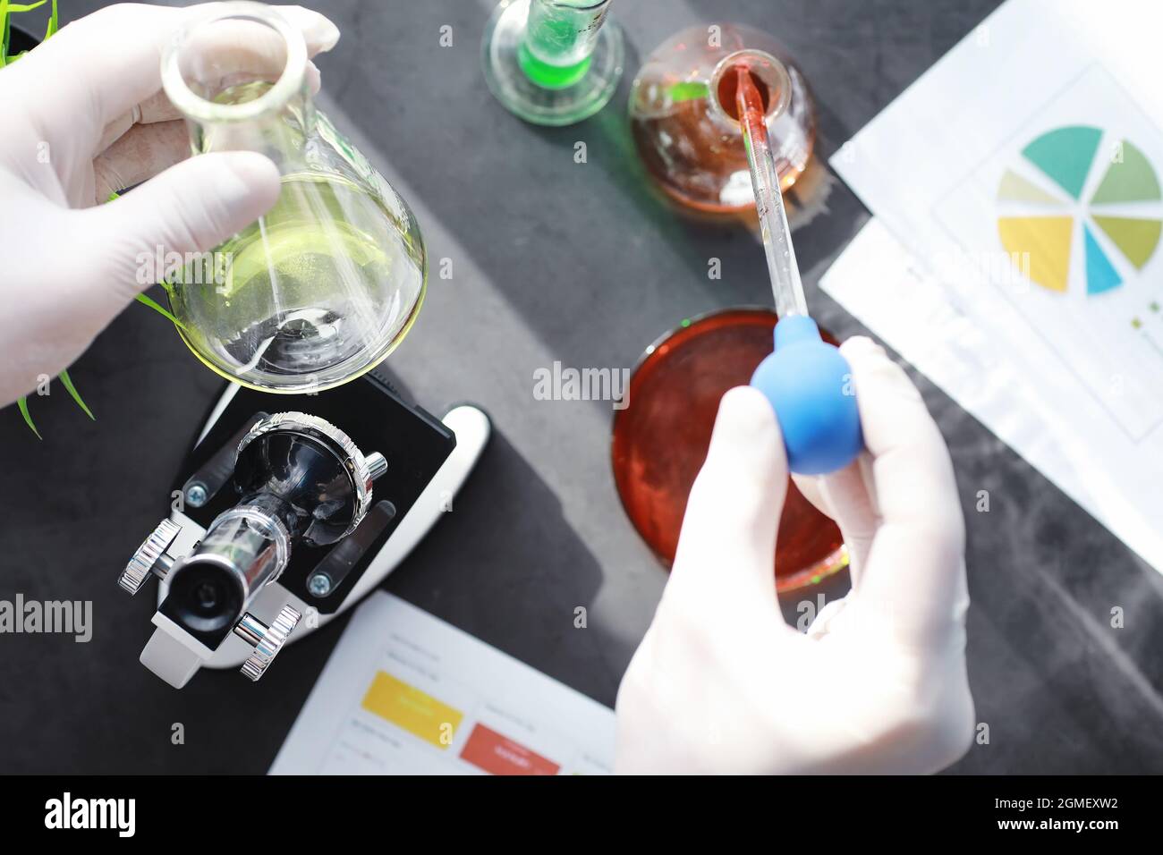 Ricerca di laboratorio. Analisi dei farmaci. Esperimenti chimici in laboratorio. Microscopio varie provette e becher sul tavolo presso il medico ufficiale. Foto Stock