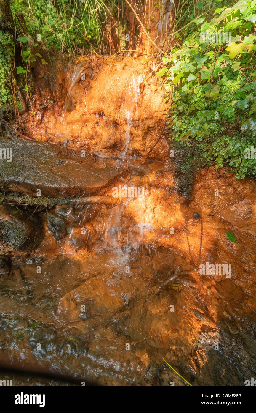 Colorazione ossido di ferro rosso in corso d'acqua che entra nel Goch Afon Foto Stock