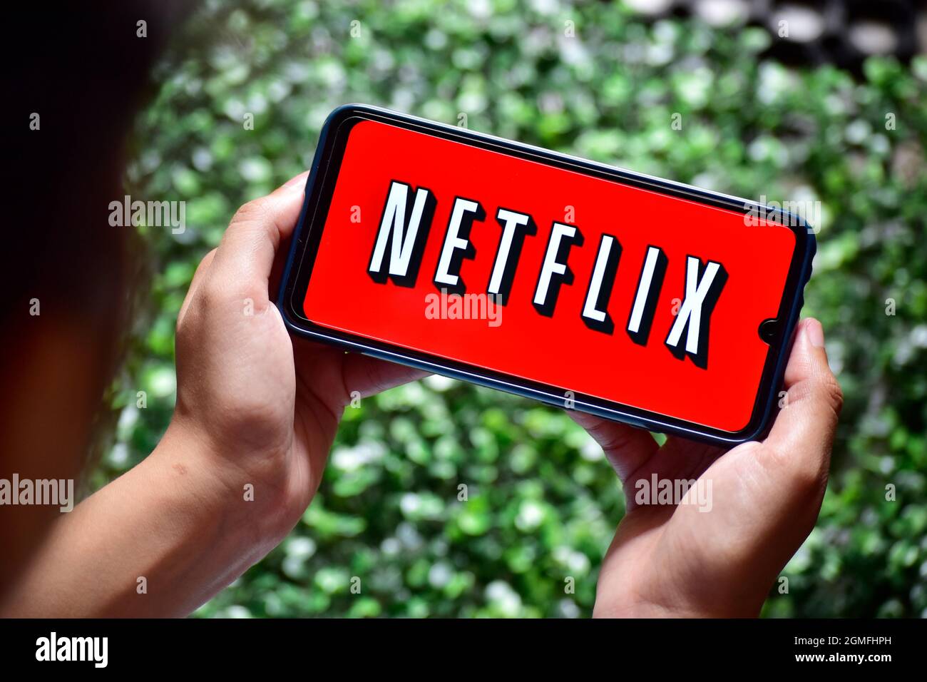 New Delhi, India - 13 settembre 2019: Smartphone donna con mano e logo Netflix. Netflix è un fornitore globale di film in streaming Foto Stock
