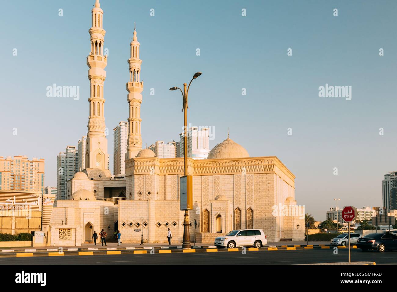 Persone a piedi vicino alla moschea di al Remeila in serata soleggiato Foto Stock