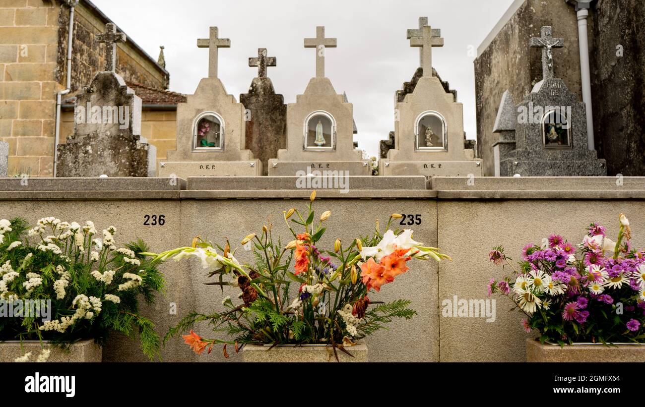 tombe in un cimitero con fiori Foto Stock