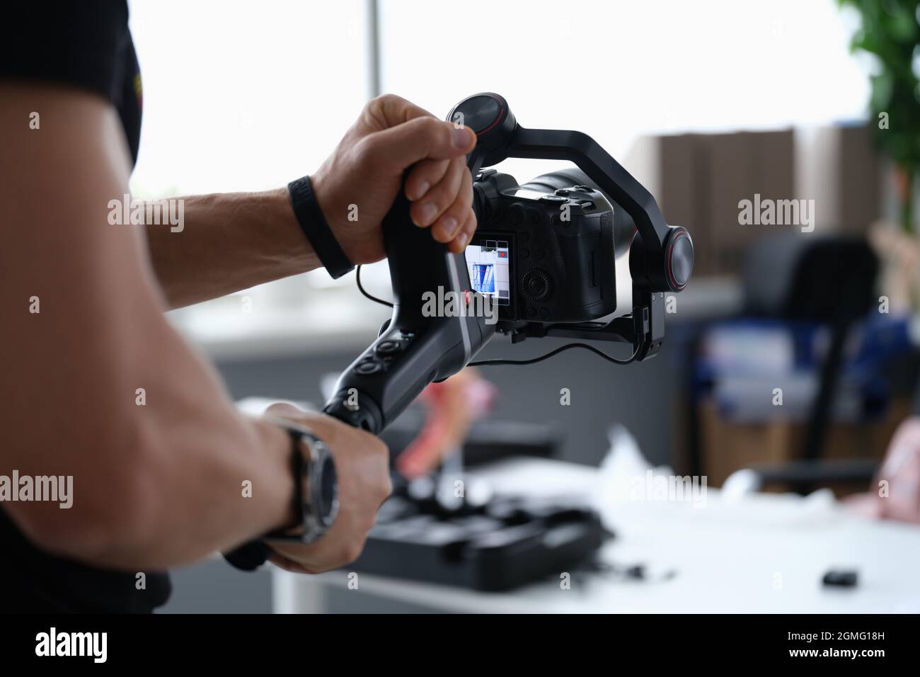 Fotografo che scatta video con la fotocamera da un primo piano del cavalletto Foto Stock