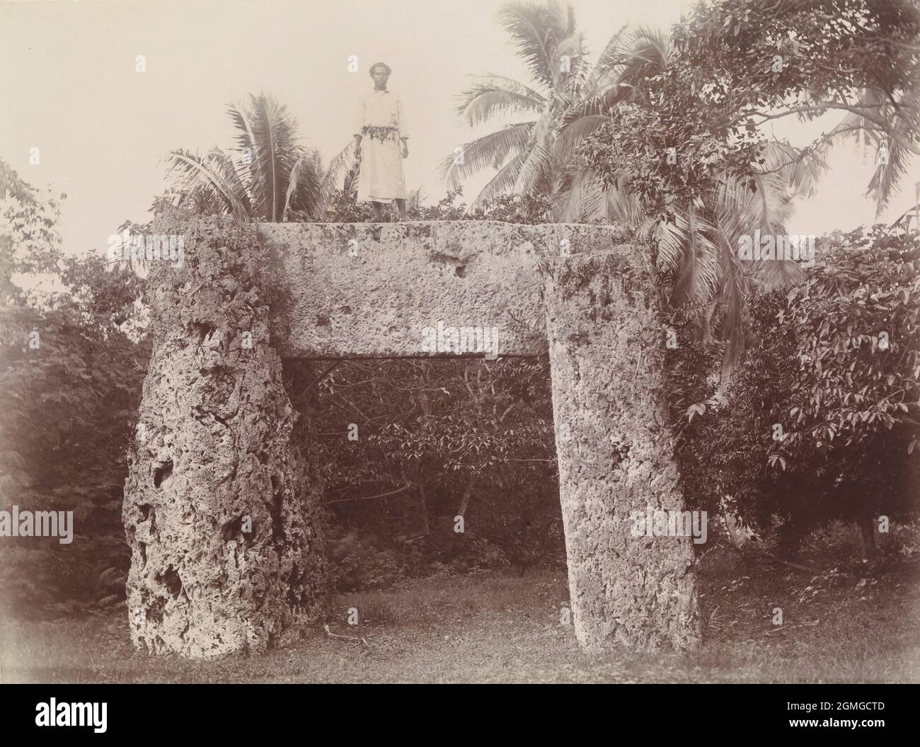 1885 foto di un uomo in piedi su haa'amonga ‘a Maui, un trilione di tre lastre di pietra corallina, vicino al villaggio di Niutōua, il sito dell'antica capitale Heketā di Tonga, nella parte settentrionale dell'isola di Tongatapu Foto Stock