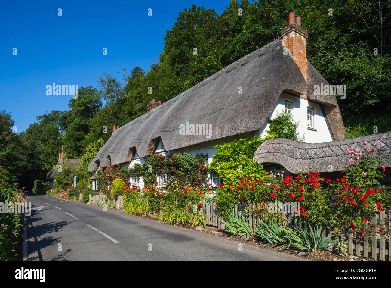 Inghilterra, Hampshire, Test Valley, Wherwell, Country House tradizionale con tetto in paglia e Empty Road Foto Stock
