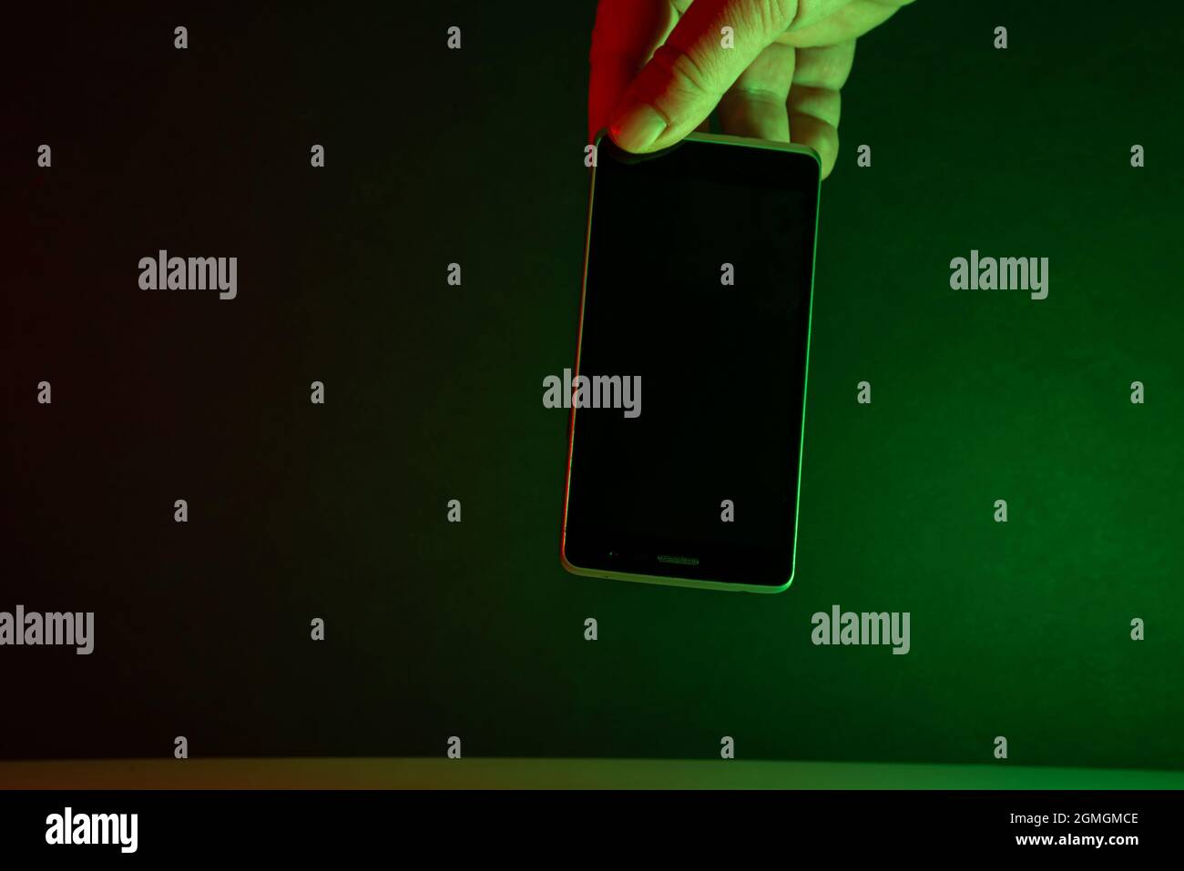 telefono cellulare con supporto a mano, sfondo verde chiaro scuro Foto Stock