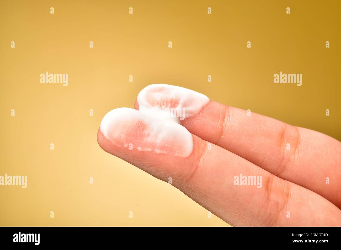 Crema idratante sulla punta delle dita Foto Stock