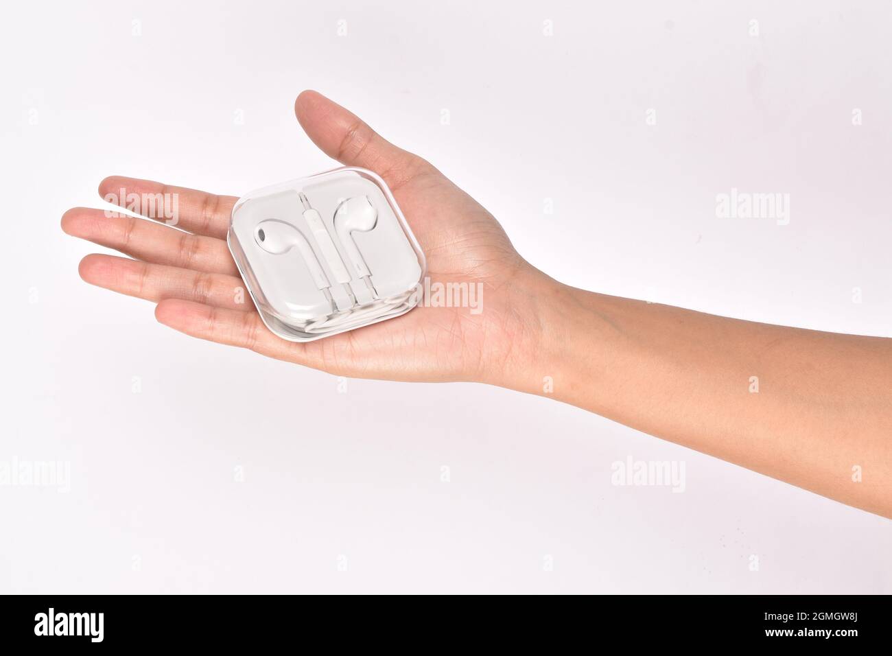 scatola di tenuta della mano dell'auricolare isolata su sfondo bianco Foto Stock