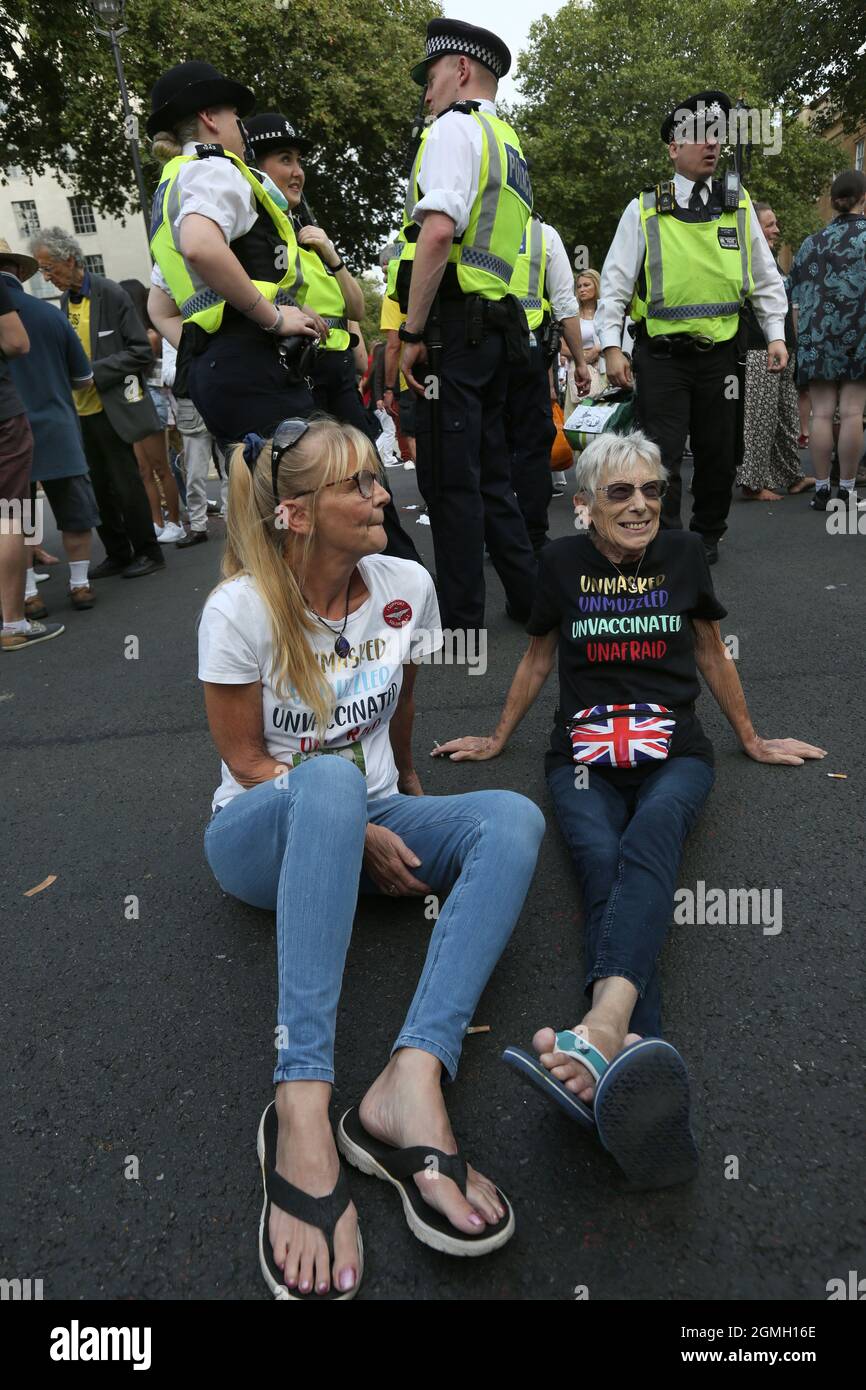 Londra, Regno Unito. 18 settembre 2021. Un paio di manifestanti si siedono in strada come manifestanti marzo da Regent's Park a Downing Street al World Wide Rally for Freedom. si marciano per i loro figli e contro la vaccinazione infantile, i passaporti dei vaccini e i futuri blocchi. Credit: SOPA Images Limited/Alamy Live News Foto Stock