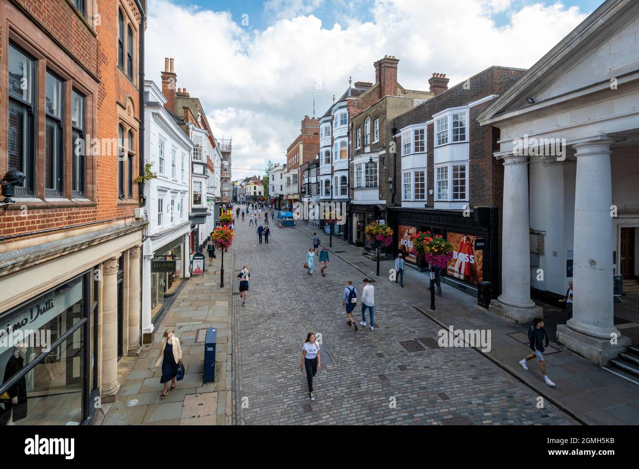 Vista di Guildford High Street nel centro della città, piena di gente che acquista in una giornata di sole, Surrey, Inghilterra, Regno Unito Foto Stock