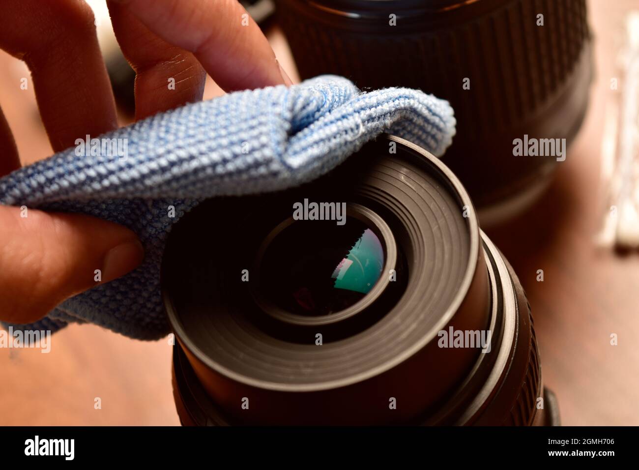 Pulizia dell'obiettivo della fotocamera con un panno Foto Stock