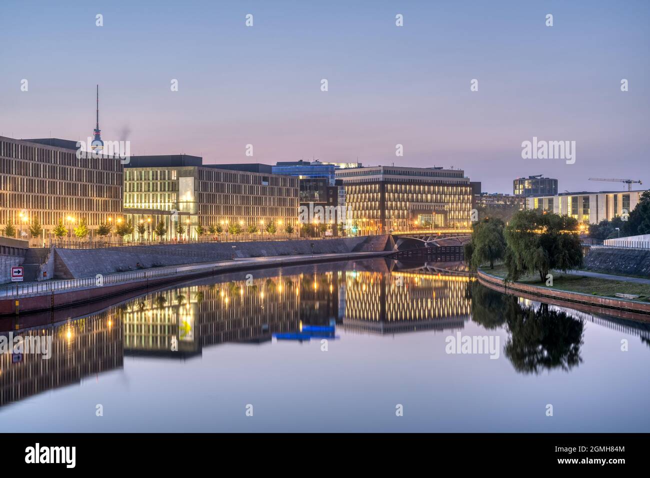 Moderni edifici di uffici al fiume Sprea a Berlino all'alba con la famosa torre della televisione sul retro Foto Stock