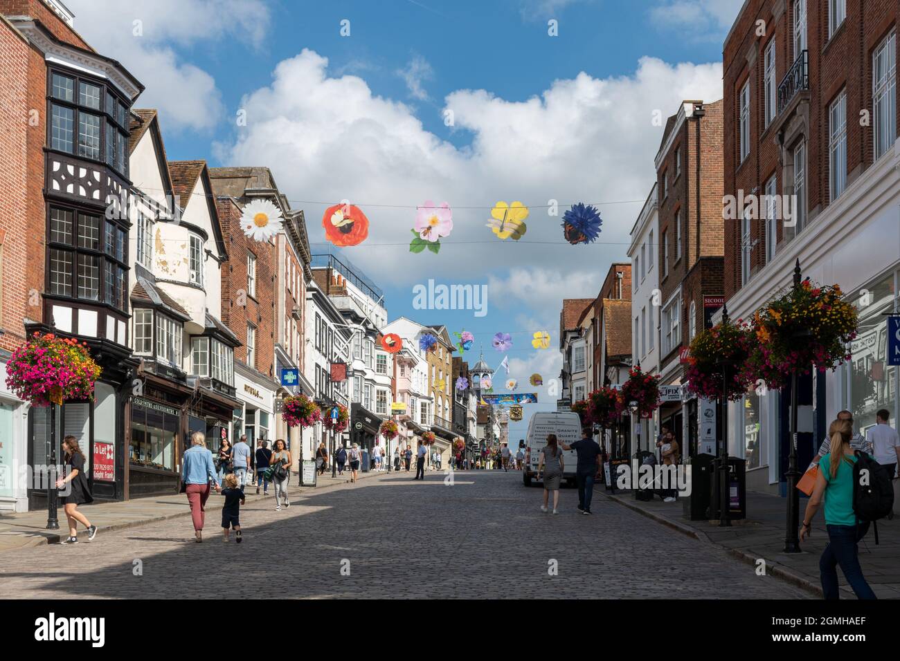 Vista di Guildford High Street nel centro della città, piena di gente che acquista in una giornata di sole, Surrey, Inghilterra, Regno Unito Foto Stock