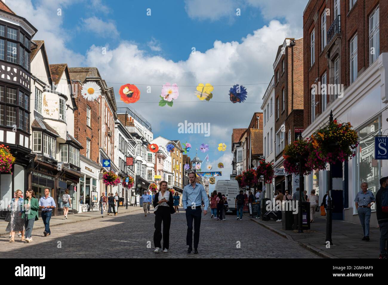 Vista di Guildford High Street nel centro della città, piena di gente che acquista in una giornata di sole, Surrey, Inghilterra, Regno Unito Foto Stock