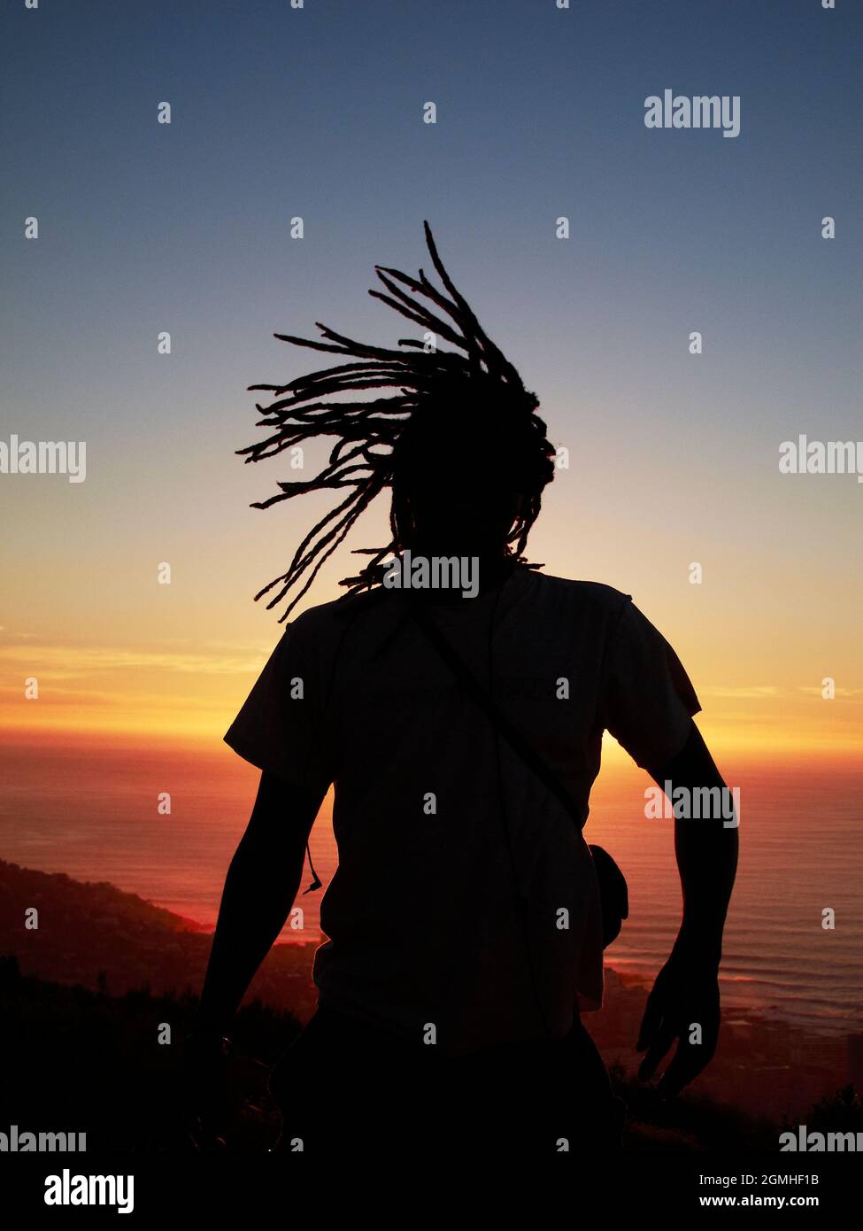 Uomo con silhouette di ciocche al tramonto Foto Stock