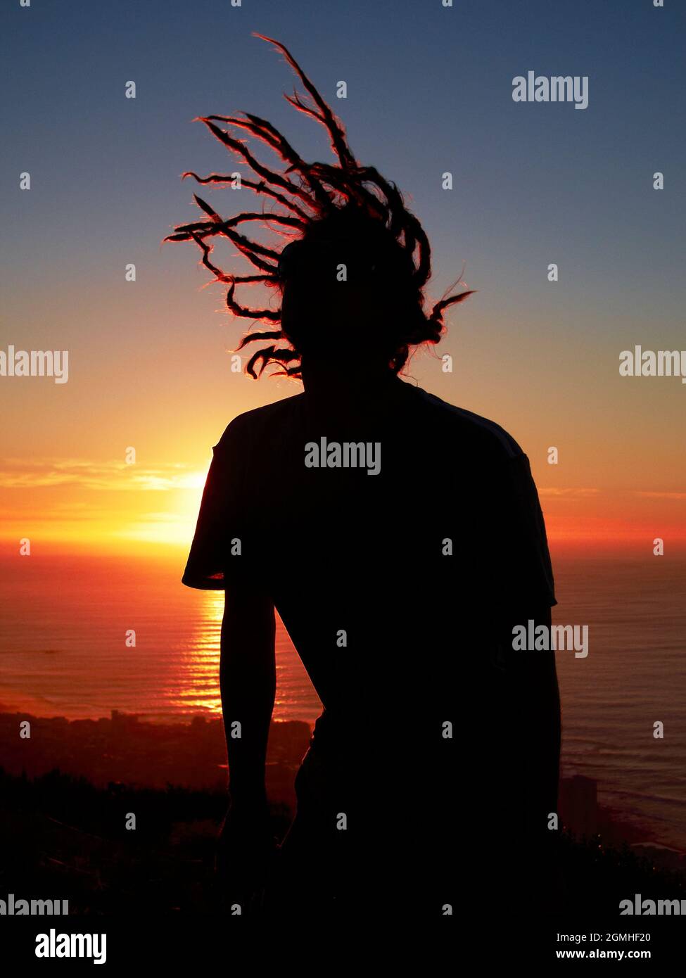 Uomo con silhouette di ciocche al tramonto Foto Stock