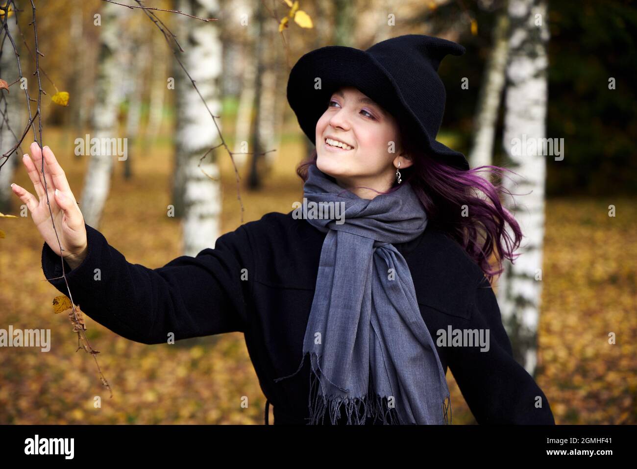 Giovane ragazza carina in un cappello, bella giornata d'autunno nel parco. Stagione festiva nel mese di ottobre. Cappello di strega di Halloween. Foto Stock