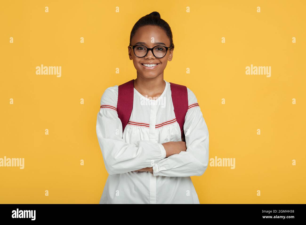 Allegro sicuro calma carina adolescente african american studentessa ragazza in occhiali con zaino a braccia incrociate Foto Stock