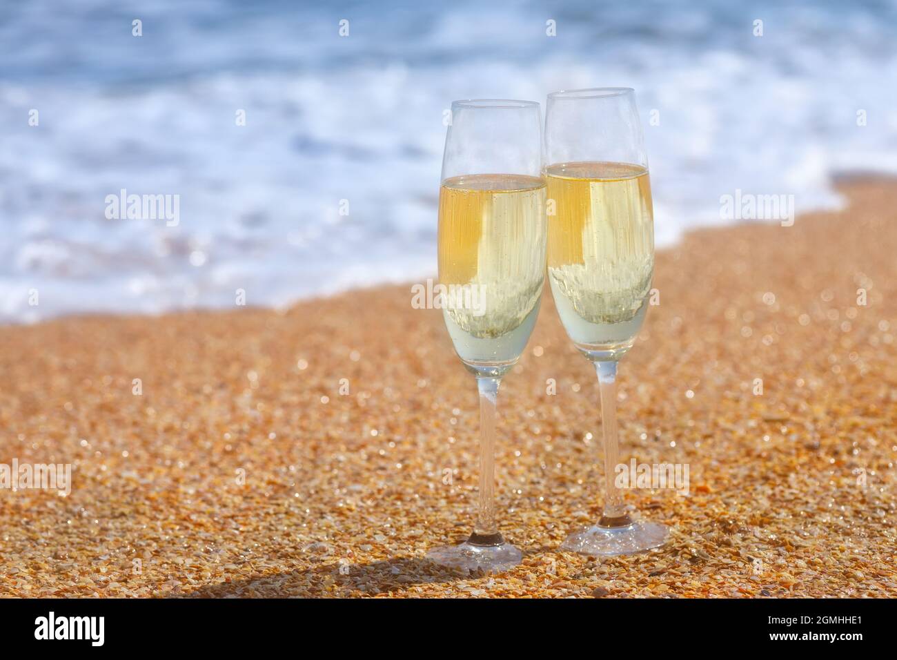 due bicchieri di champagne sulla spiaggia di mare Foto Stock