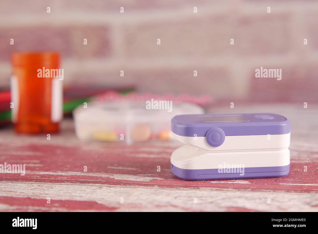 pulsossimetro, pillole mediche e blister sul tavolo Foto Stock
