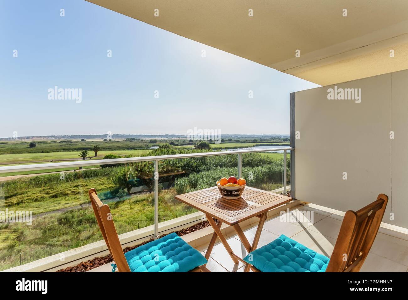 Terrazza con balcone, vista lago e parco, con sedie e un tavolo e frutta per pic-nic e riposo per i turisti. Foto Stock