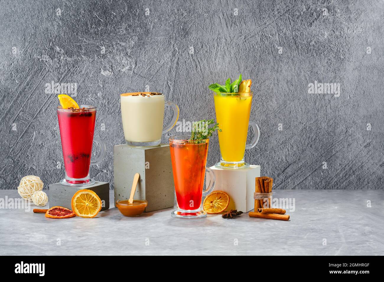 Composizione con frutta calda e bevande invernali alle erbe su sfondo grigio shabby Foto Stock