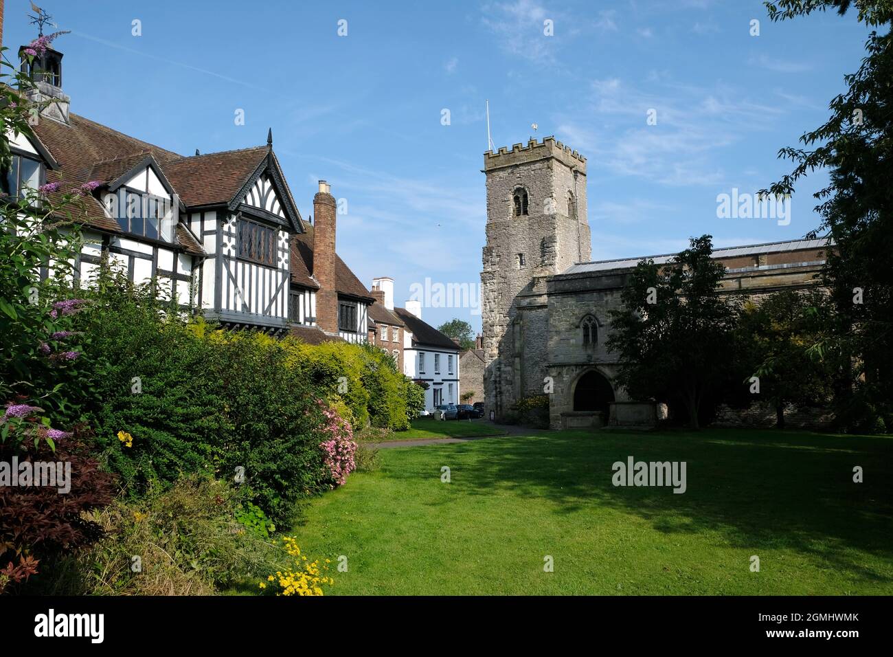 La torre normanna della chiesa parrocchiale della Santissima Trinità, a destra, e la vecchia Guildhall, a sinistra, in molto Wenlock, Shropshire, Inghilterra, REGNO UNITO Foto Stock