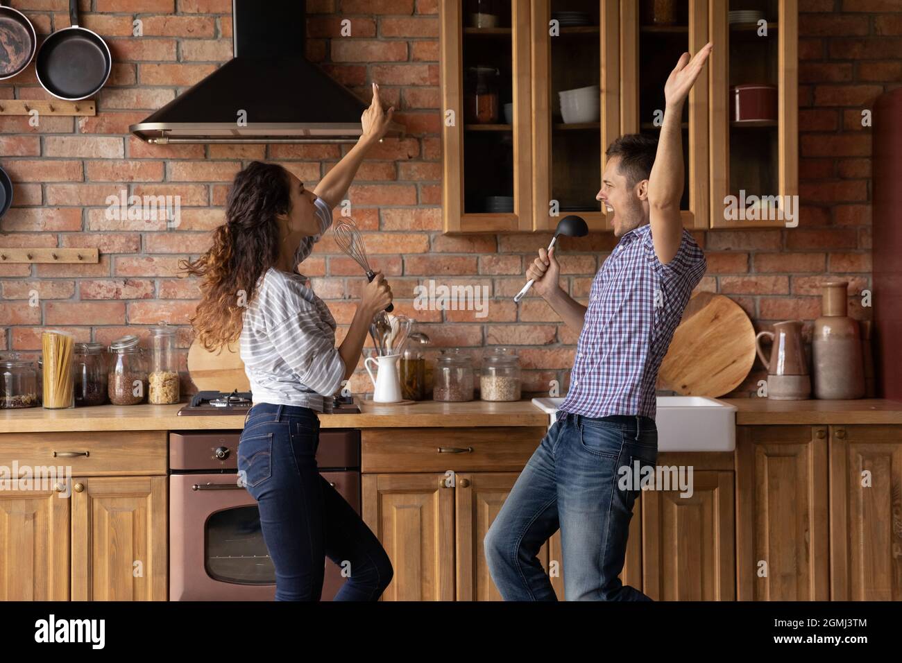 Sorgioiata giovane coppia sincera di famiglia che si diverte in cucina. Foto Stock