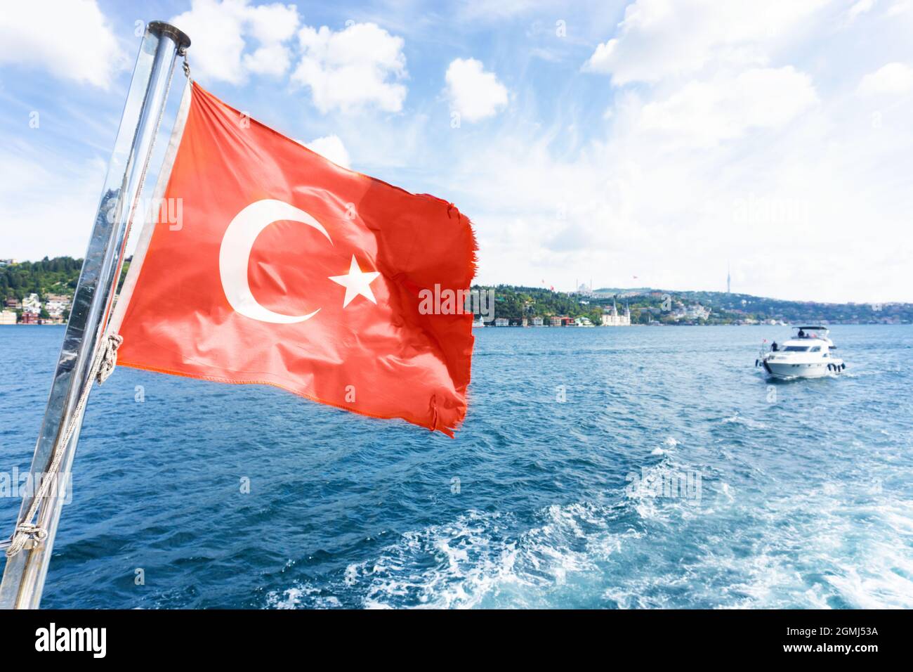 Vista in barca della bandiera nazionale della Turchia e della costa di Istanbul durante la crociera sul Bosforo Foto Stock