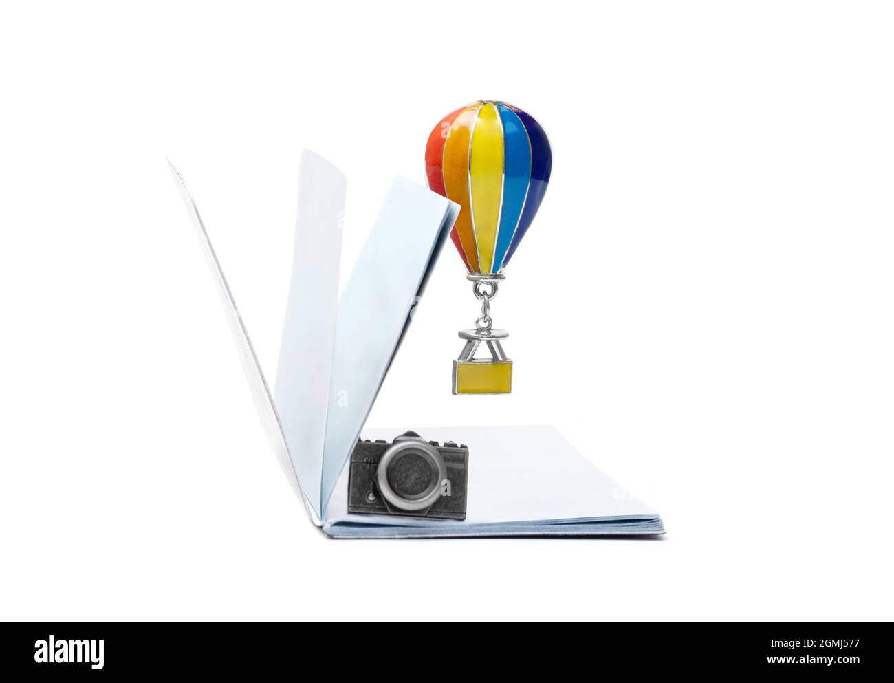 Passaporto vuoto con una figurina della macchina fotografica e un pendente del palloncino dell'aria hovering isolato su bianco. Vacanza romantica in Europa. Foto Stock