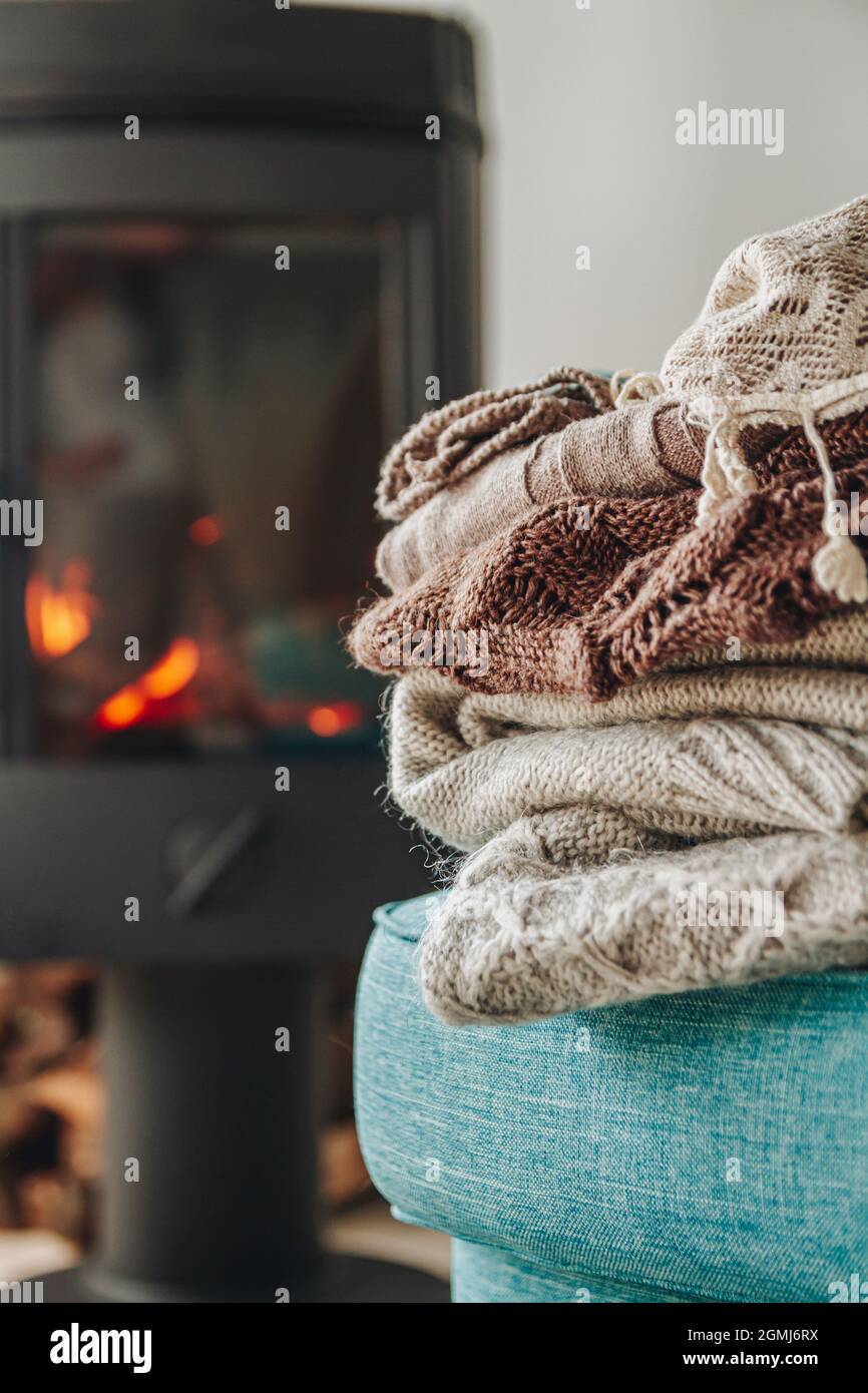 Una pila di vestiti caldi su una poltrona un camino di ferro con un Foto Stock