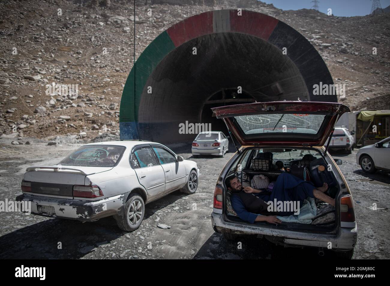 Passo di Salang, Afghanistan. 19 Settembre 2021. Un uomo afghano riposa nel bagagliaio di un'auto mentre altri veicoli entrano nel tunnel di Salang attraversando l'Hindu Kush sul Passo di Salang, il passo di montagna primario che collega l'Afghanistan settentrionale con la Provincia di Parwan, con collegamenti in avanti con la Provincia di Kabul. Credit: Oliver Weiken/dpa/Alamy Live News Foto Stock