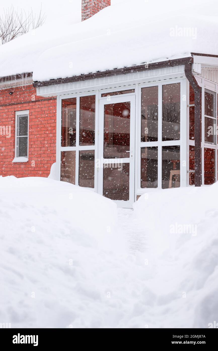 Vetro porta anteriore di casa in mattoni con neve durante la Blizzard Foto Stock