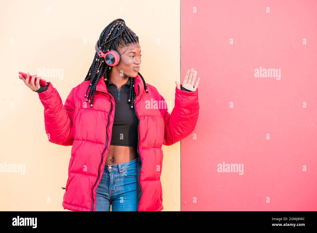 Bella donna africana ballare all'aperto. Donna nera che ascolta musica con le cuffie Foto Stock