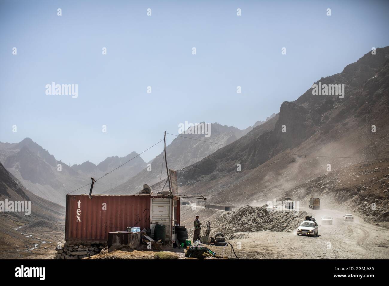 Passo di Salang, Afghanistan. 19 Settembre 2021. Un venditore afghano guarda avanti, mentre auto e camion attraversano il Kush Hindu sul Passo Salang, il passo di montagna primario che collega l'Afghanistan settentrionale con la Provincia di Parwan, con collegamenti in avanti con la Provincia di Kabul. Credit: Oliver Weiken/dpa/Alamy Live News Foto Stock