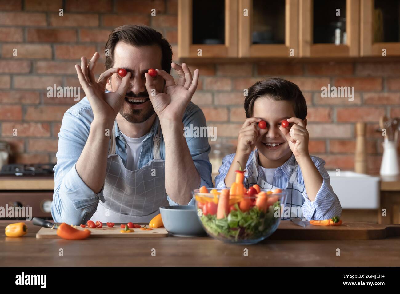 Testa ritratto ritratto padre e figlio divertirsi con i pomodori Foto Stock