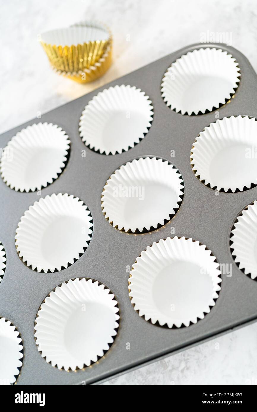 Foderare la teglia per cupcake con i fodere per preparare i cupcake di s'mers. Foto Stock