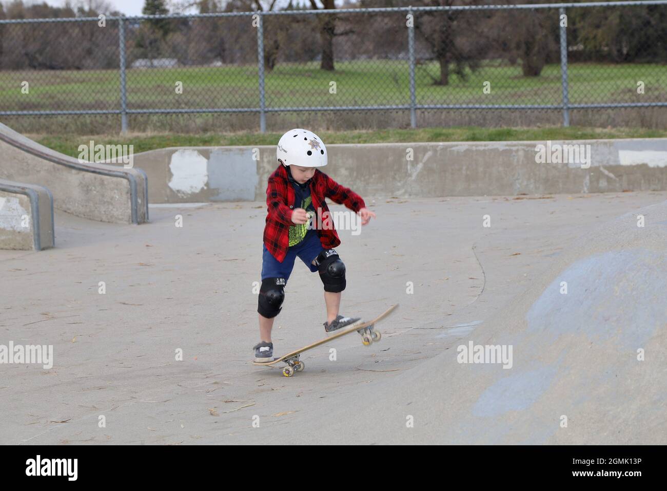 Piccoli skateboarder al parco skate Foto Stock