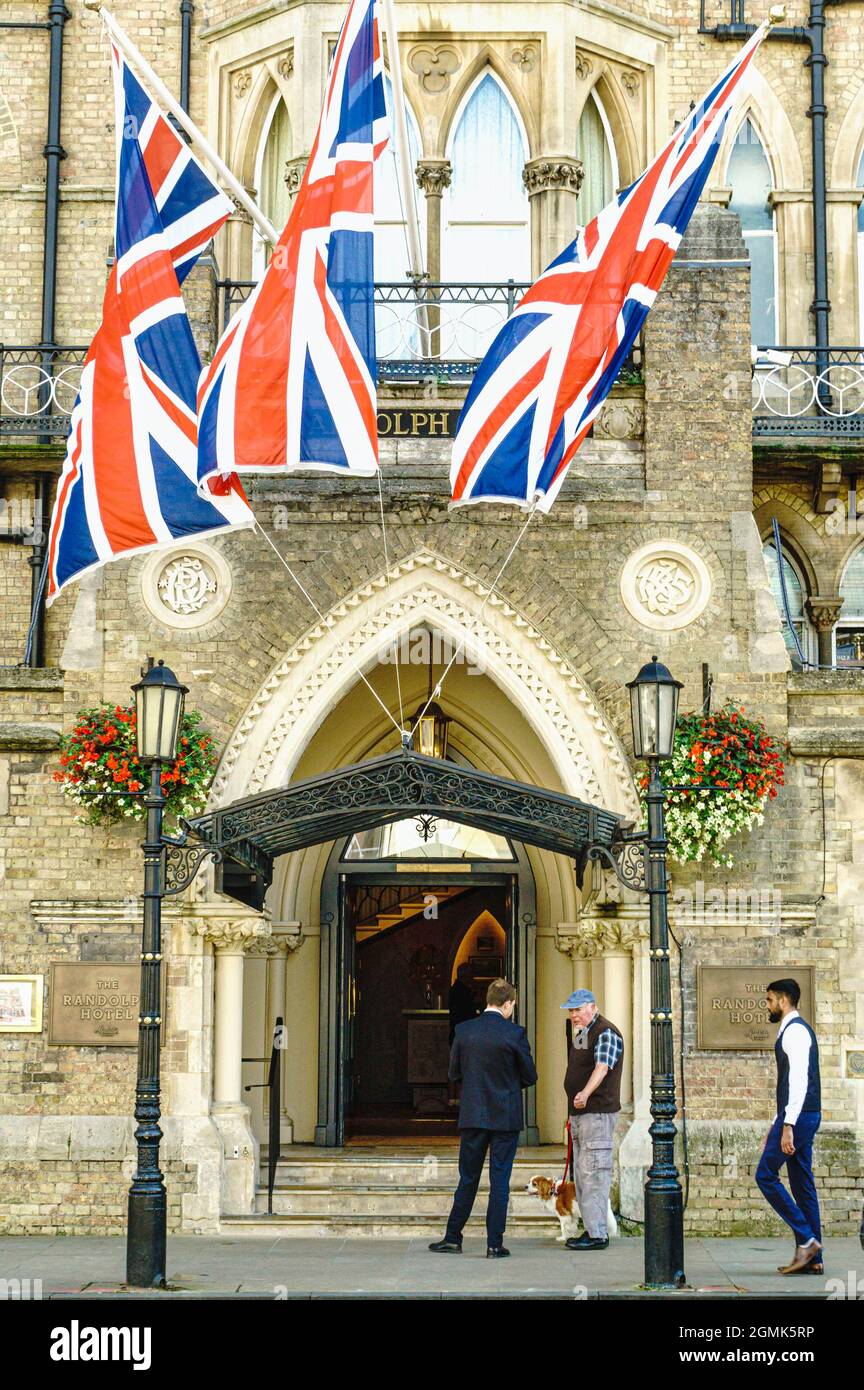 L'Union Jack vola sopra il Randolph Hotel, Beaumont Street, Oxford, Regno Unito. Un uomo si ferma a parlare con il personale dell'hotel. Foto Stock