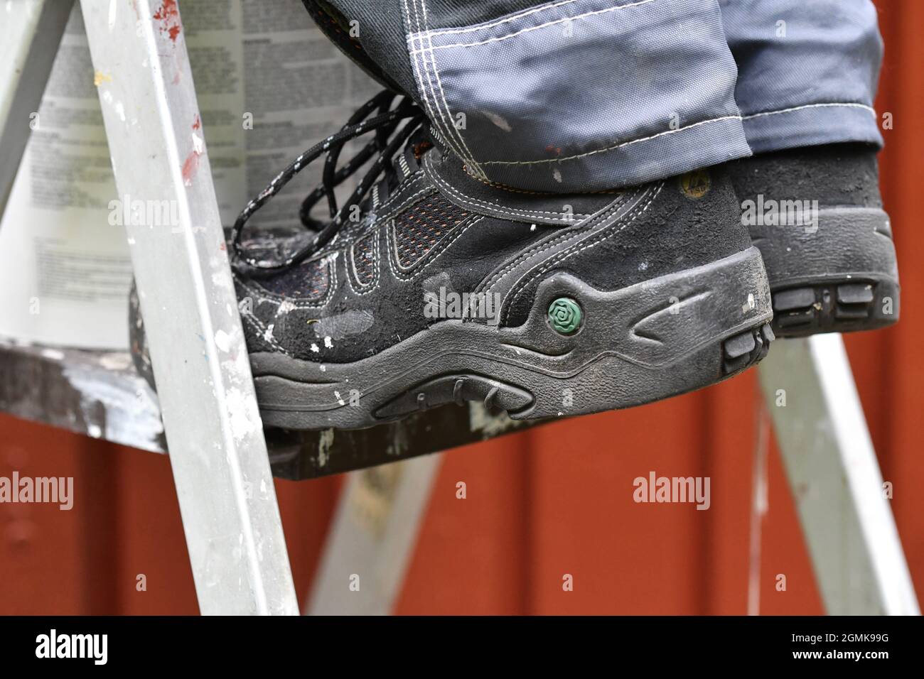 Primo piano delle scarpe di pittore o lavoratore che fa casa ristrutturazione o miglioramento Foto Stock