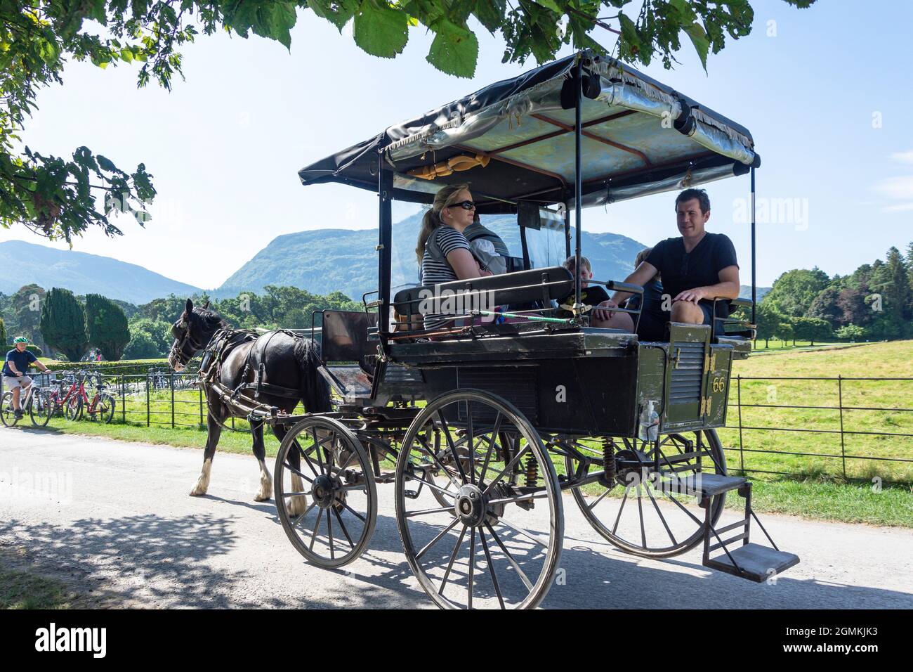 Corsa in carrozza a cavallo di famiglia alla casa di Muckross 19 ° secolo, il Parco Nazionale, Killarney (Cill Airne), County Kerry, Repubblica d'Irlanda Foto Stock