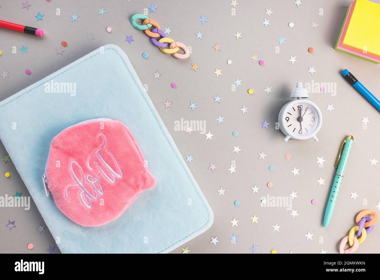 Libro di esercizi, penna, matite, orologio. Concetto di scuola Foto Stock