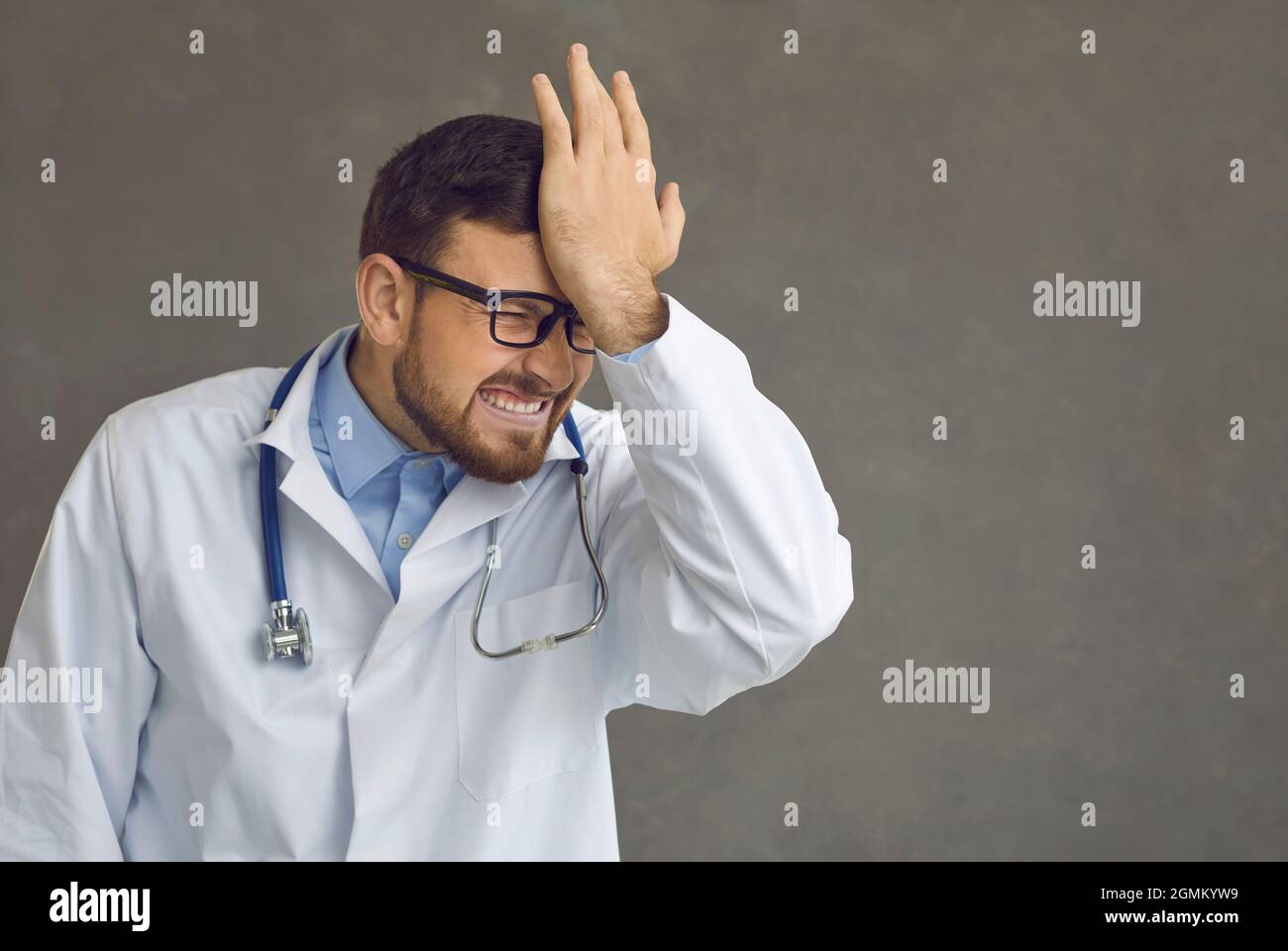 Il medico schiaffe la sua fronte come ricorda il suo stupido errore e fallimento professionale Foto Stock