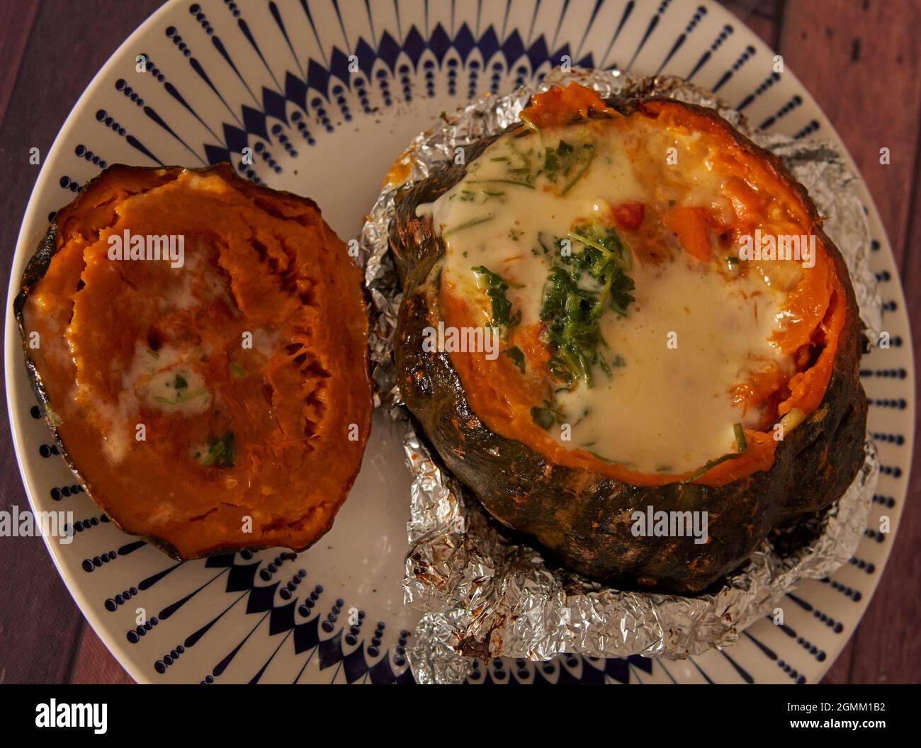 Deliziosa zucca farcita ripiena cotta al forno con lamina di alluminio. Orizzontale Foto Stock