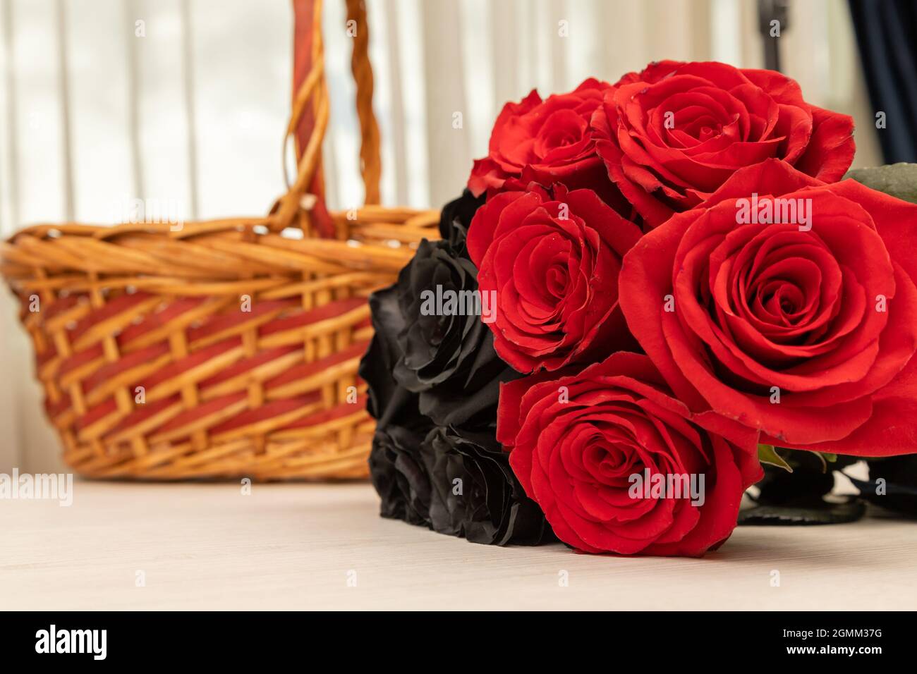 bouquet con rose nere e rosse, dietro un cesto, bella decorazione romantica  con bellezza della natura su un tavolo, dettaglio dei petali e texture Foto  stock - Alamy