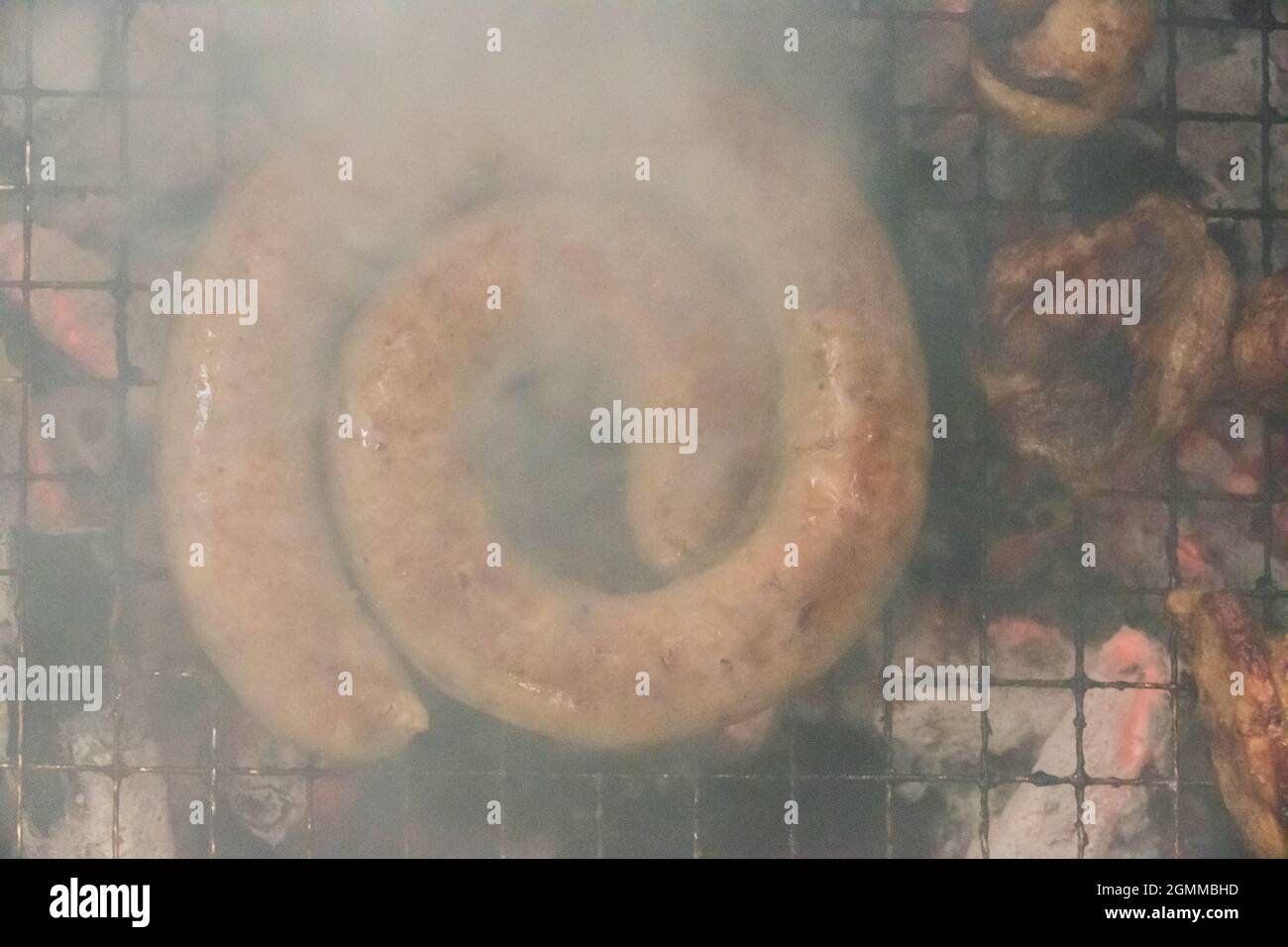 Serpentina di salsiccia in stile sudafricano grigliata su un barbecue, vista dall'alto Foto Stock