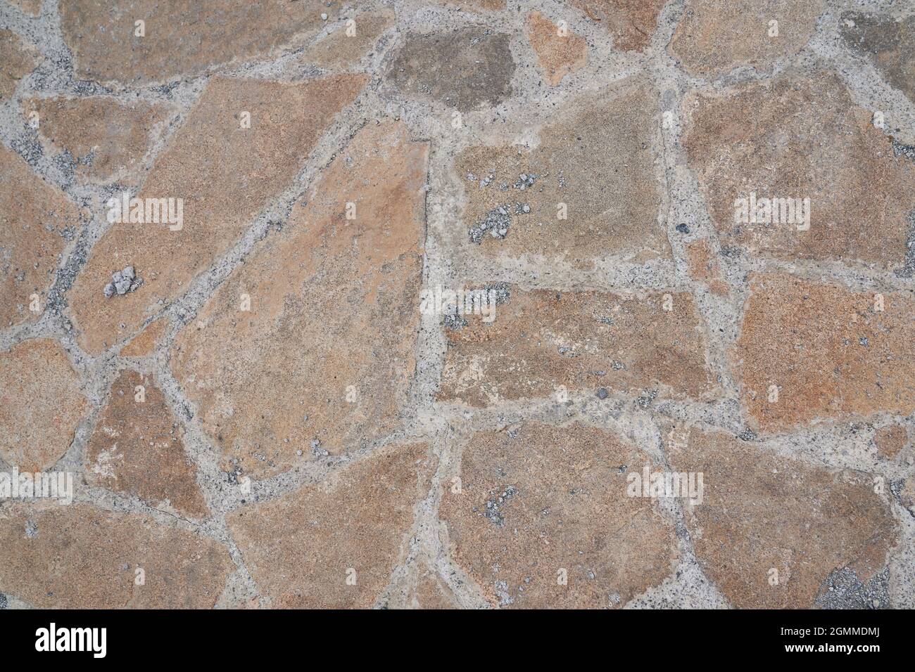 Superficie stradale arancione in pietra. Trama senza giunture. La tessitura di una strada di pietra. Foto di alta qualità Foto Stock