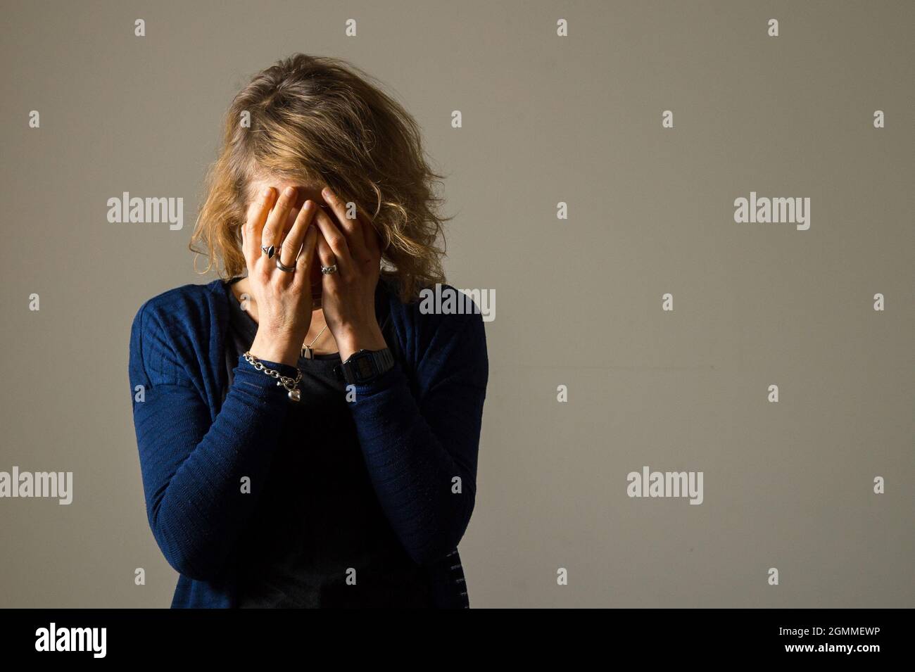 FOTO POSATA DAL MODELLO file foto datata 09/03/15 di una donna con la testa nelle mani. Gli esperti hanno avvertito che sono urgentemente necessari ulteriori fondi per aiutare i circa 1.6 milioni di persone che sono in attesa di cure per la salute mentale in mezzo alla pandemia. Il Royal College of Psychiatrists ha detto che 1.5 milioni di persone hanno ricevuto il sostegno NHS salute mentale nel mese di giugno, ma molte altre sono in disperato bisogno di cure. Data di emissione: Lunedì 20 settembre 2021. Foto Stock