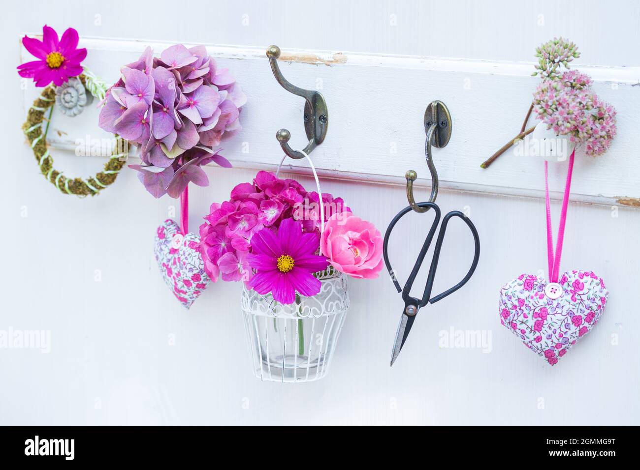 decorazione con bouquet di fiori estivi rosa e cuori di tessuto Foto Stock