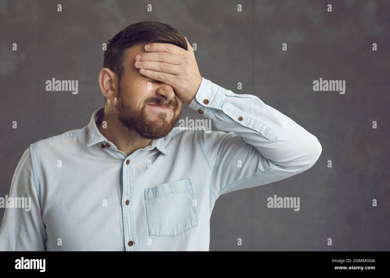 L'uomo facepalming sentendosi vergognoso e imbarazzato di uno stupido errore che ha fatto Foto Stock