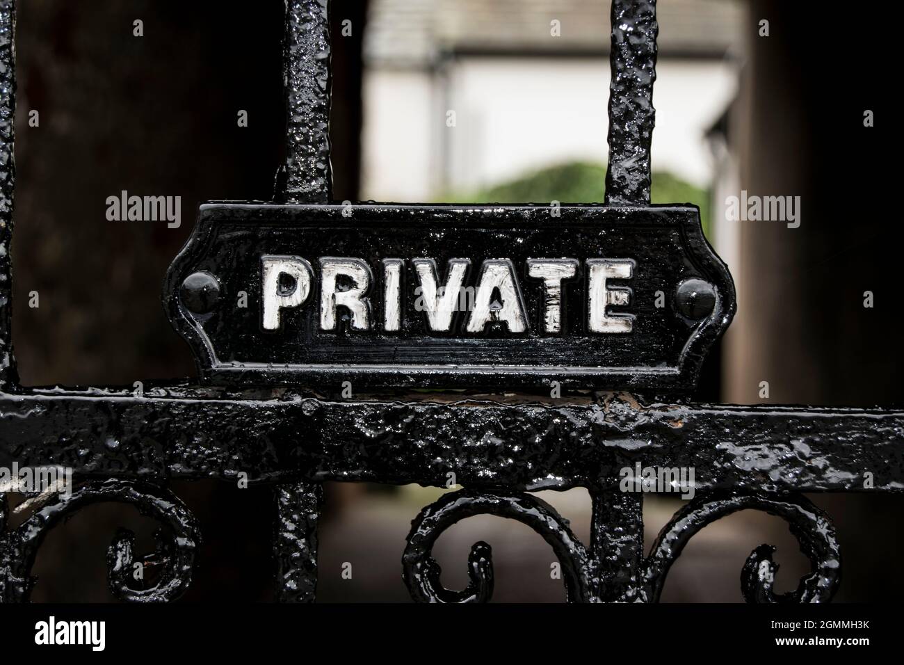 Segnaletica privata su un cancello ornamentale in metallo nero Foto Stock